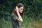 Woman in the forest Green suit rest corrects hair background nature