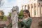 Woman in foro romano texting with the smartphone