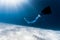 Woman freediver glides over sandy bottom