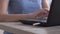 Woman freelance inserts a flash card into a laptop and typing on keyboard, hands close up