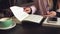 Woman freelancer leafing through pages of a diary in a coffee shop. Entrepreneur working in cafe. Business woman uses