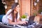 Woman freelancer, travel blogger works on a laptop. sitting on a lounger in the garden