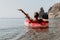 Woman freelancer works on laptop swimming in sea on pink inflatable ring. Happy tourist floating on inflatable donut and