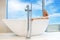 woman in freestanding white bath. Modern bathroom interior design. Beauty, healthy lifestyle concept