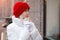 Woman frozen in the cold on city streets in winter in a red knitted hat