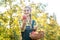 Woman on fruit orchard showing apple into the camera