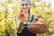 Woman on fruit orchard showing apple into the camera