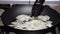 Woman frying onion into the pan in the kitchen.