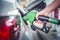 Woman fueling car at petrol station.