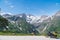 Woman in full biker outfit, copy space. Touring motorcycle with big bags. The snowy peaks of the Johannisberg and Hohe Dock