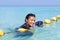 Woman in a full-body swimsuit lying on yellow buoys