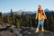 Woman in full height smile with teeth happiness hiker in yellow raincoat jumps up on the mountain trip in the fall and