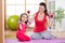 Woman with funny child do exercise lifting dumbbells