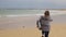 Woman funny running in beach close to ocean