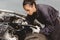 Woman garage worker maintenance checklist at automobile service center, Female in auto mechanic car technician work service check