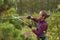 Woman gardener cuts pine using secateurs