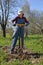 Woman gardener digging ground bed in her spring garden