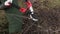 Woman gardener near branches using scissors in garden