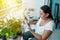 Woman gardener taking care of plants on her balcony.