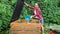 Woman gardener throwing out kitchen waste to the garden compost heap for recycling and fertilizer. Recycling concept.