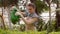 Woman gardener is working in the garden, watering green seedlings with watering can.