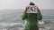 woman in gas mask with poster - peace stands by the sea