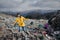 Woman with gas mask walking on landfill, environmental concept.