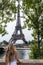 Woman gazing the Eiffel tower from the river in Paris