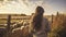 A Woman Gazing Thoughtfully at a Flock of Sheep by a Wooden Fence