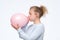 Woman in gblue sweateris blowing pink balloon preparing for birthday party