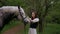 Woman gently petting horse in peaceful woodland setting. Serene moment as woman walks and bonds with horse among trees.