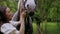 Woman gently petting horse in peaceful woodland setting. Serene moment as woman walks and bonds with horse among trees.