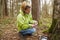 A woman geocaching. Women in woods find geocache.