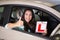 Woman gesturing thumbs up holding a learner driver sign