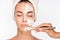 Woman getting beauty skin mask treatment on face with brush