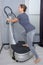 Woman getting on vibrating platform fitness machine