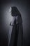 Woman ghost in hooded cloak over dark background