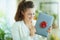 Woman and gift laptop with red bow in modern house in sunny day