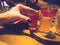 Woman, girl holds in her hand with a manicure on her fingers a delicious red glass, a shot with strong alcohol, vodka, brandy