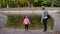 A woman with a girl in the park by the pond feed the ducks