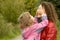 Woman and girl playing in garden, girl closes eyes