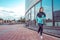 Woman girl in summer jogging in city, sportswear windbreaker leggings. Free space for text. In the morning, a sport