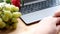 Woman, girl surfing the internet in a laptop, closeup keyboard, fruit, flowers, work at home, workplace, downshifting, blogger,