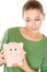 Woman giving her piggy bank a speculative look