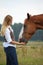 Woman giving horse a treat