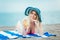 Woman with glass of cocktail in hand lying on sand beach