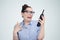 Woman in glasses screams into a telephone receiver on background