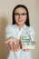 Woman in glasses shows dollars and dice
