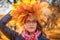 A woman in glasses with a wreath of yellow maple leaves on her head. Female portrait in the rays of the autumn sunset