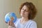 Woman with globe in hands thinking about traveling